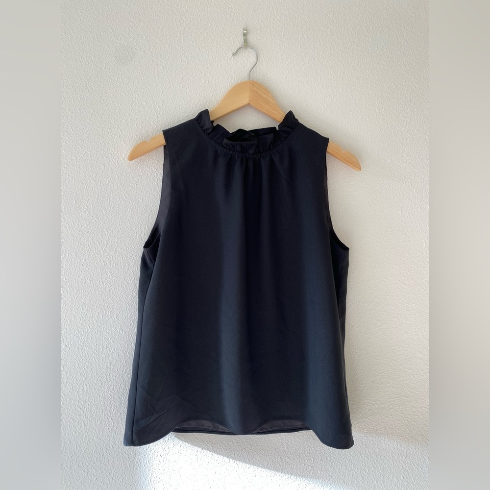 Sleeveless ruffle neck blouse.
